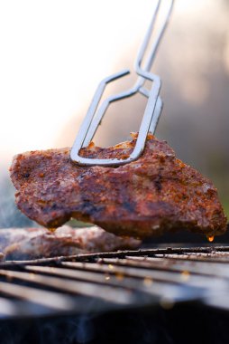 Bbq closeup with metal tongs clipart