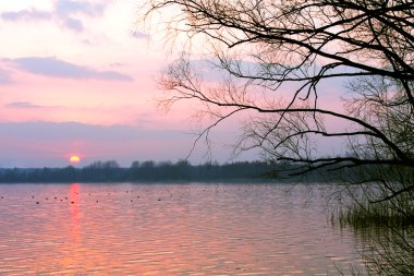 Göl üzerinde kırmızı günbatımı