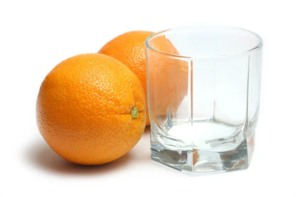 Пустое стекло и два апельсина — стоковое фото