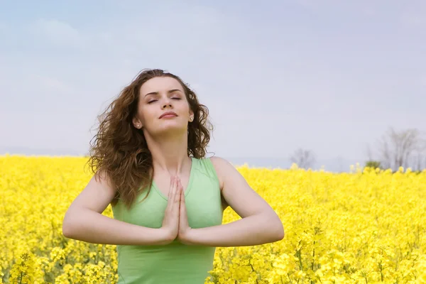 Jovem mulher orando ou fazendo ioga no rap — Fotografia de Stock