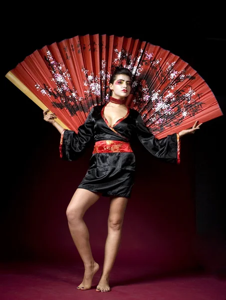 Schöne Geisha mit einem großen Fächer — Stockfoto