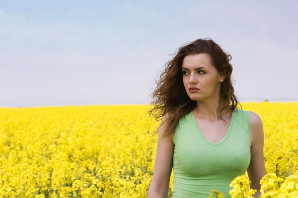 Lonely young woman in rape flower field — Stock Photo, Image