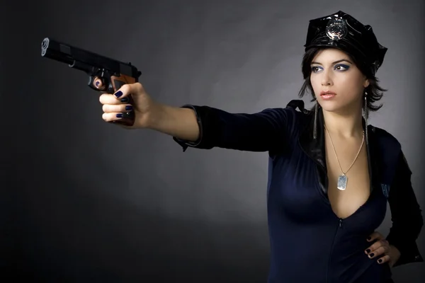 Sexy Polizistin mit Waffe Stockbild