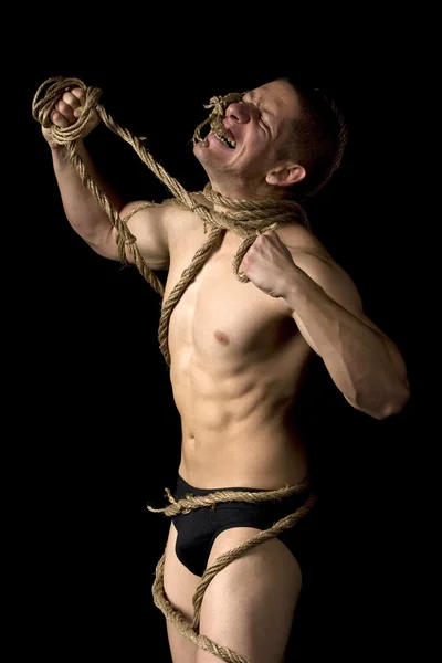 Mocny młody człowiek związany z lin — Zdjęcie stockowe