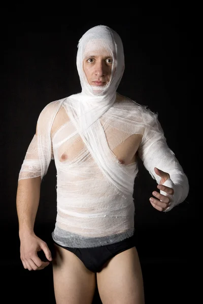 Bandażowane w sposób młody człowiek w studio na czarny ba — Zdjęcie stockowe