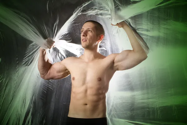Junger starker Mann im Atelier mit grünem Bauch — Stockfoto