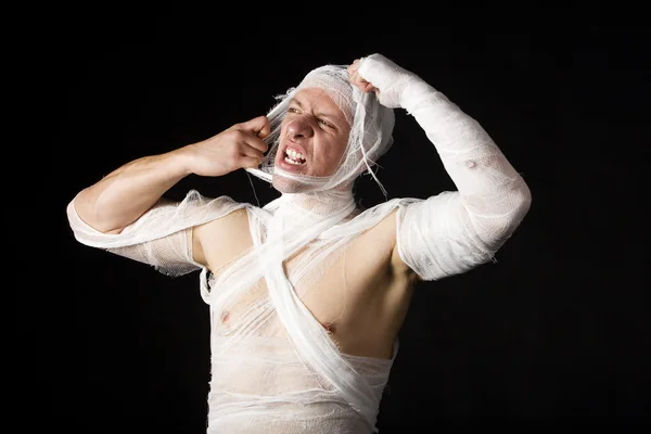 Bandaged jeune homme en studio sur noir ba — Photo