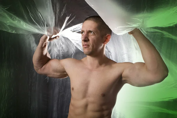 М'язистий юнак на зеленому абстрактному сірому Стокова Картинка
