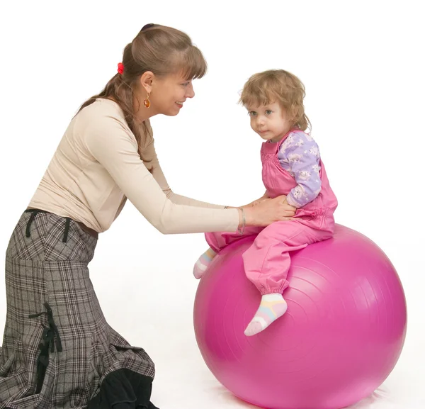 La femme balance l'enfant sur fitball — Photo