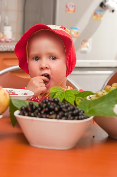 Маленька дівчинка їсть ягоду — стокове фото