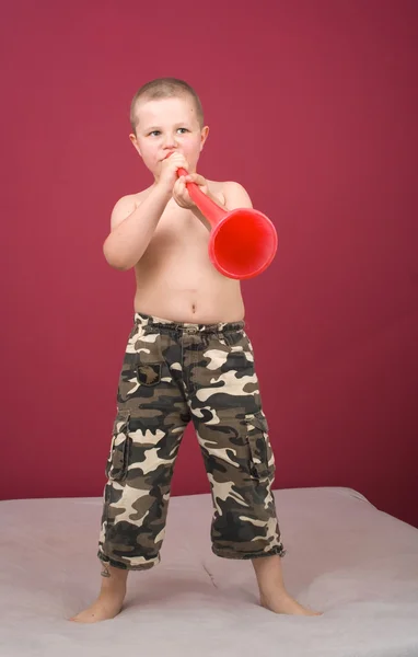 Мальчик трубит в трубу. — стоковое фото