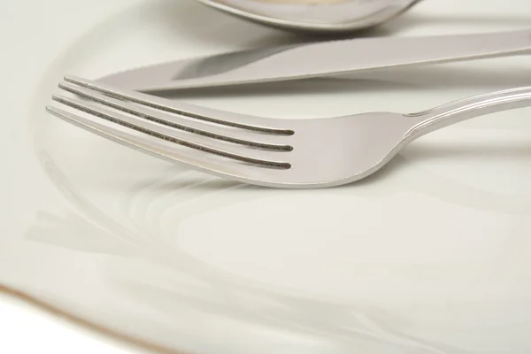 Empty plate with knife and fork — Stock Photo, Image