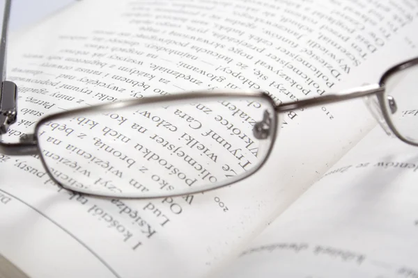 上一本打开的书的阅读眼镜 — 图库照片