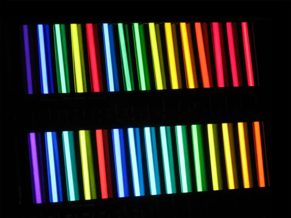 Tubos de cor arco-íris no fundo preto — Fotografia de Stock