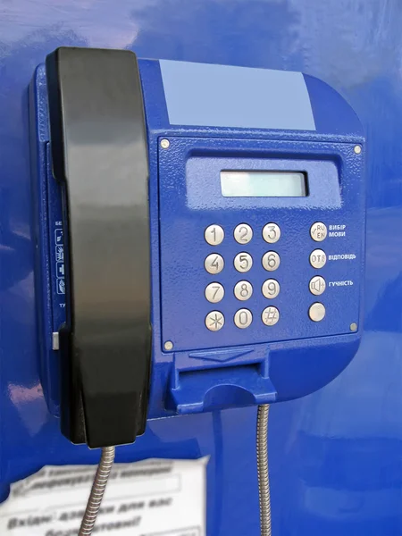 Blue street public telephone with number — Stock Photo, Image