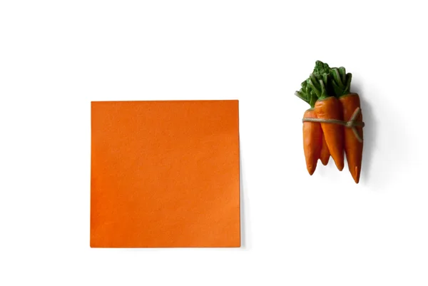 Pomarańczowy karteczkę i marchew na białym tle — Zdjęcie stockowe