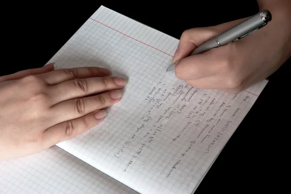 Kvinnan skriver i en anteckningsbok som skolan — Stockfoto