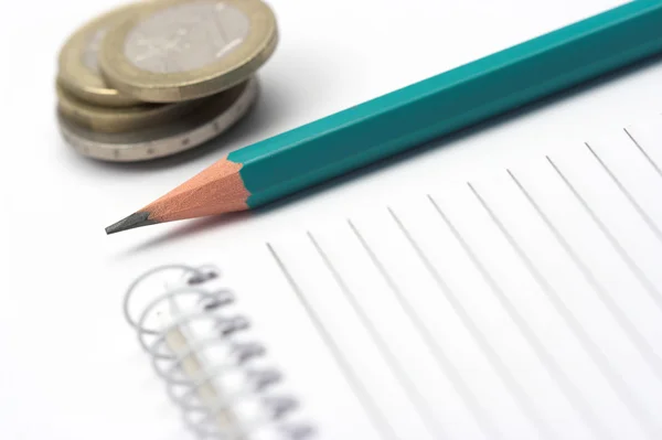 Ручка, монеты и блокнот — стоковое фото