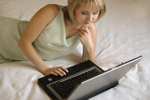 Το κορίτσι με το φορητό υπολογιστή σε ένα κρεβάτι β — Φωτογραφία Αρχείου