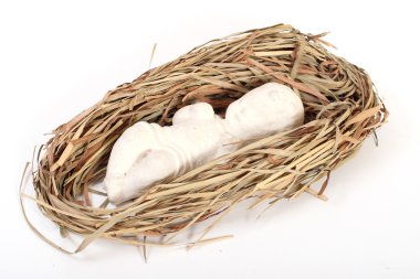 Baby Jesus figurine lying on hay clipart