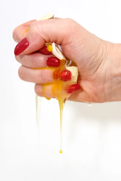 A női kéz megnyomja egy tojás — Stock Fotó