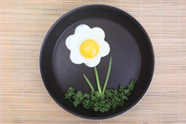 Flower shaped fried egg with greenery Royalty Free Stock Images