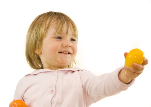 Cute girl presenting orange ball — Stock Photo, Image