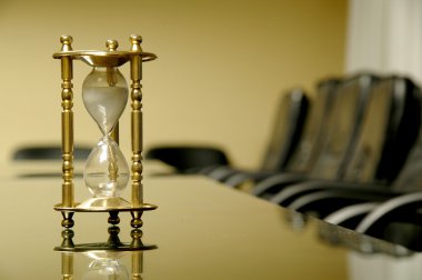 Sand clock in the empty board room clipart