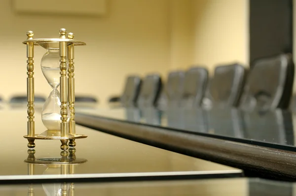 Relógio de areia na sala de conferências vazia — Fotografia de Stock