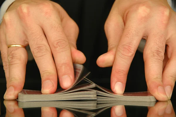 Zwei Hände, die ein Kartenspiel in einem Casino mischen — Stockfoto