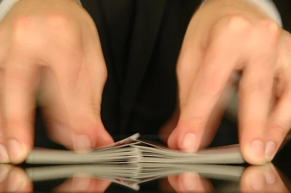 Две руки перетасовывают колоду карт в казино — стоковое фото