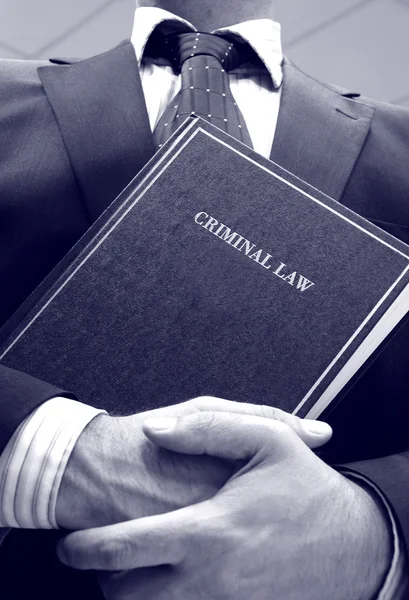 Адвокат тримає книгу кримінального права — стокове фото