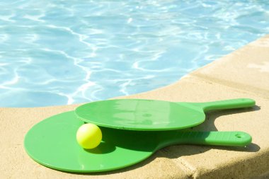 Rackets on a pool's edge clipart