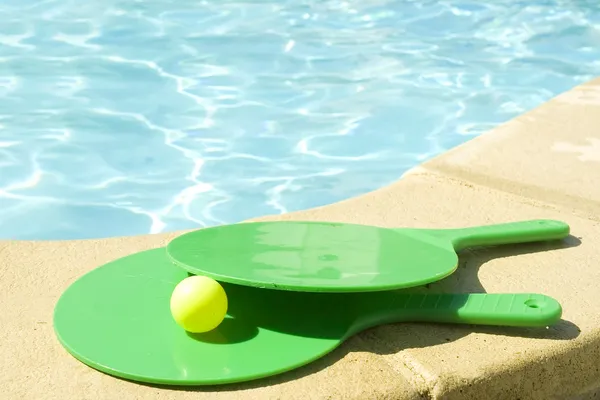 Rackets on a pool's edge — Stock Photo, Image
