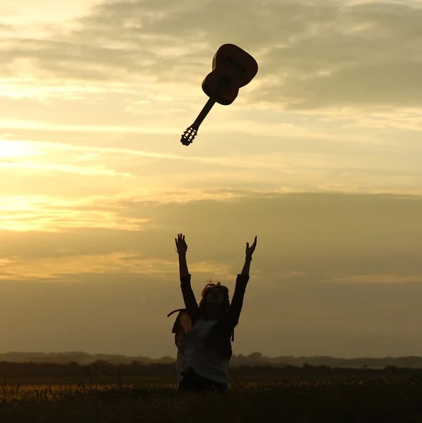 Person throwing a guitar into the air — Stock Photo, Image