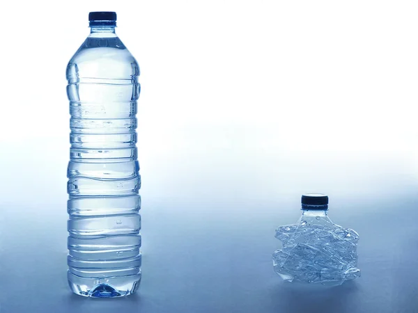 Botella llena y triturada de agua — Foto de Stock