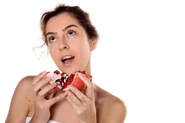 Brünette Frau beißt in einen Granatapfel — Stockfoto