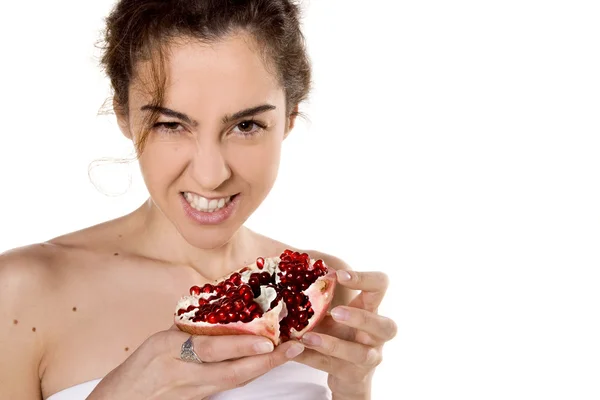 Brunette woman biting a pomegranate — Stock Photo, Image