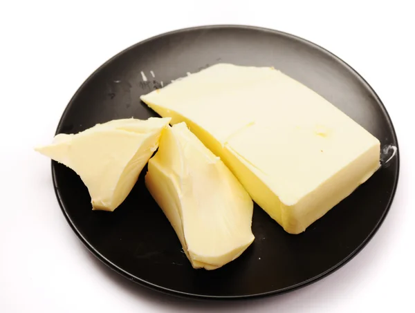 Mentega pada mentega hitam hidangan terisolasi o — Stok Foto