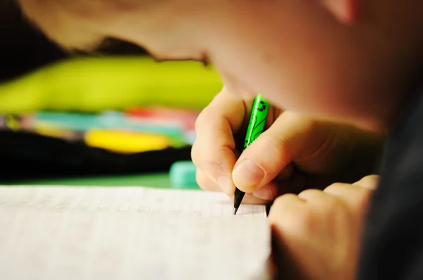 Kid in klas met pen in de hand — Stockfoto