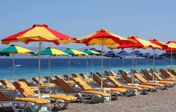 Plaża z łóżka i kolorowe parasole — Zdjęcie stockowe