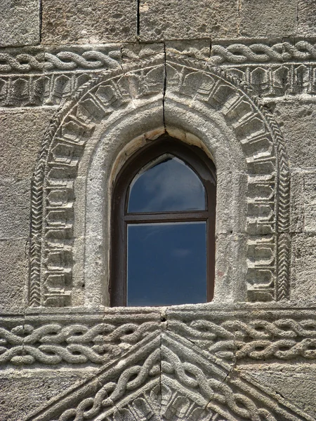 Fenêtre et mur de pierre avec sculpture — Photo