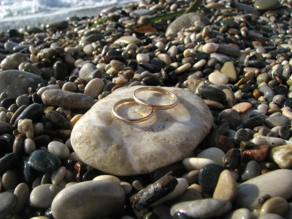 Anéis de casamento de ouro na praia — Fotografia de Stock