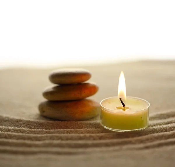Stack of pebbles and light candle Stock Picture