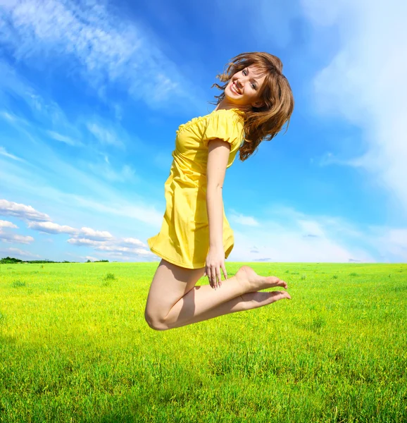 Gelukkig jonge vrouw springen in de weide — Stockfoto