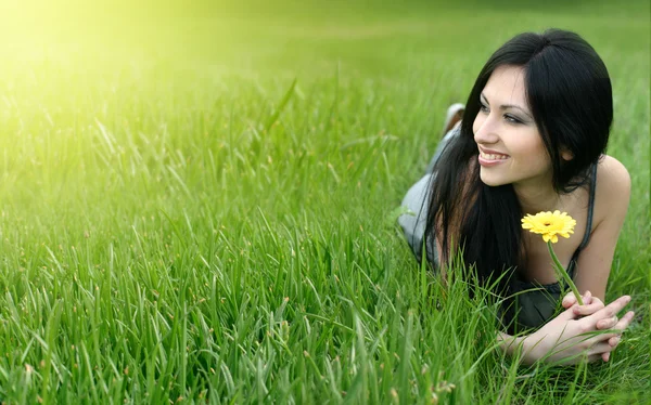 Bela jovem mulher relaxante na grama — Fotografia de Stock
