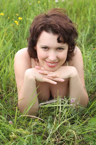 Vacker kvinna i grönt gräs — Stockfoto