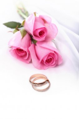 Wedding rings and pink roses