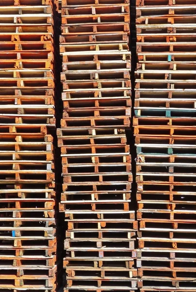 Colunas de paletes de madeira empilhadas — Fotografia de Stock