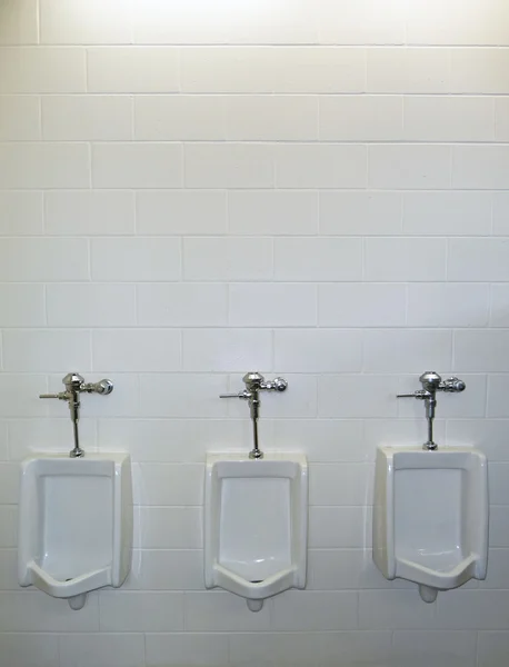 Trois urinoirs avec fond blanc — Photo